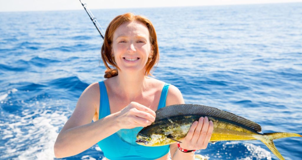 a woman holding a big fish during a deep-sea fishing tour on the Big Island, Hawaii