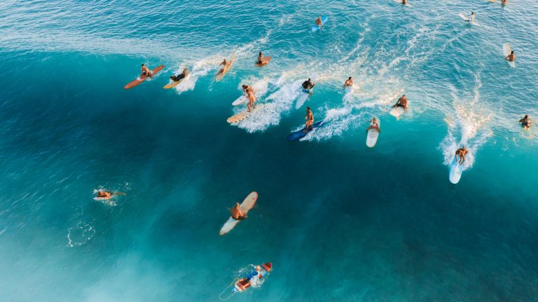 people surfing on blue waters