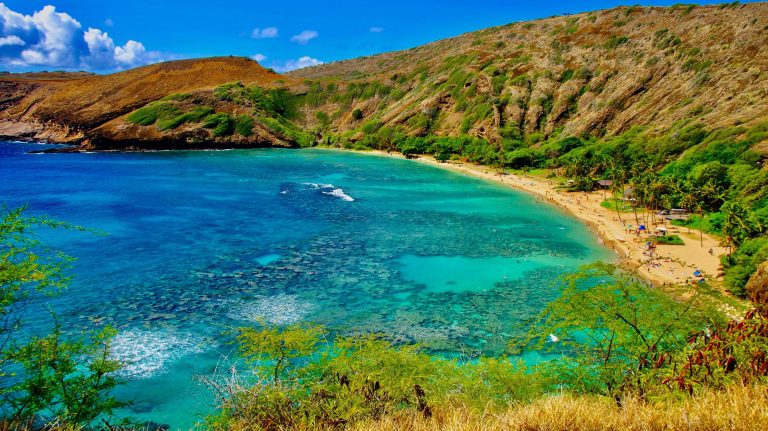 beautiful beach with a large body of water, surrounded by hills