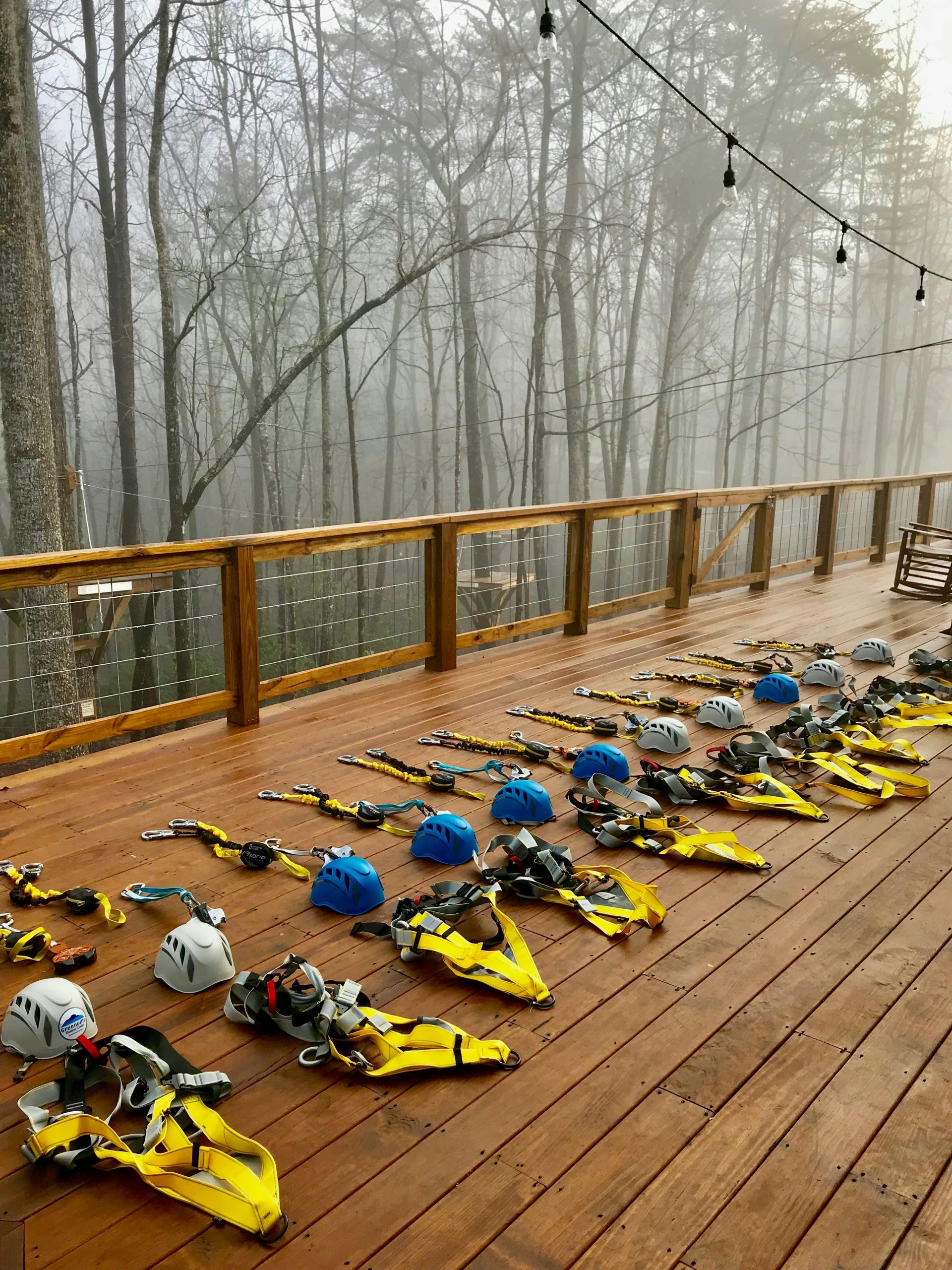 A row of zipline gears on a wooden deck.