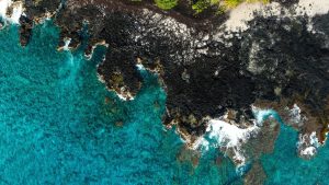 Rocky coast with lava rocks and clear blue water