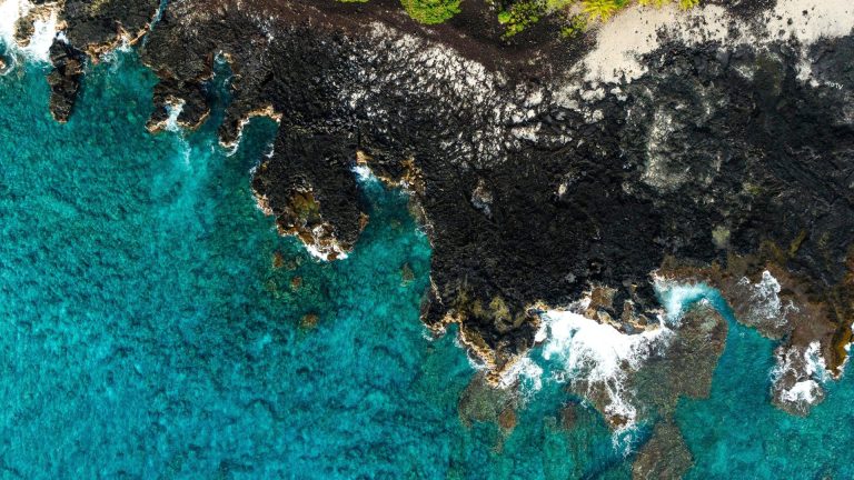 Rocky coast with lava rocks and clear blue water