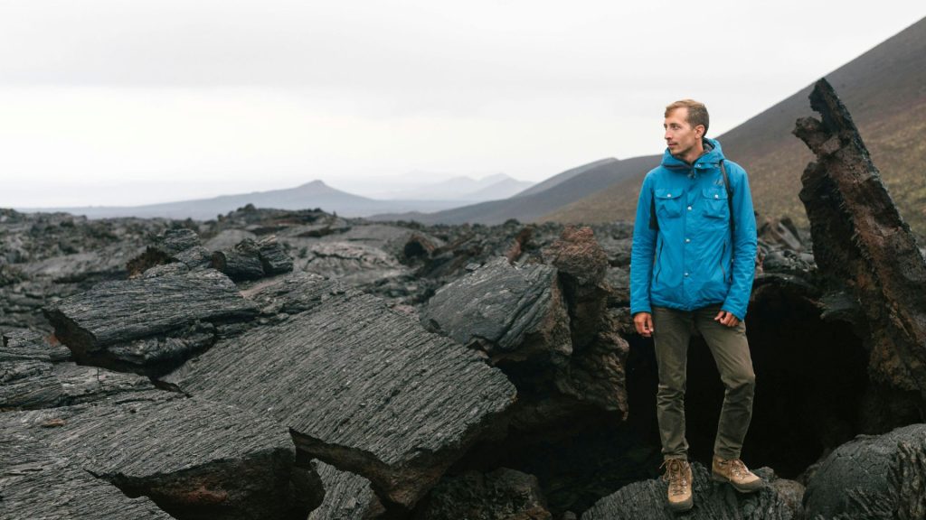 Man standing on some of the black lava rocks